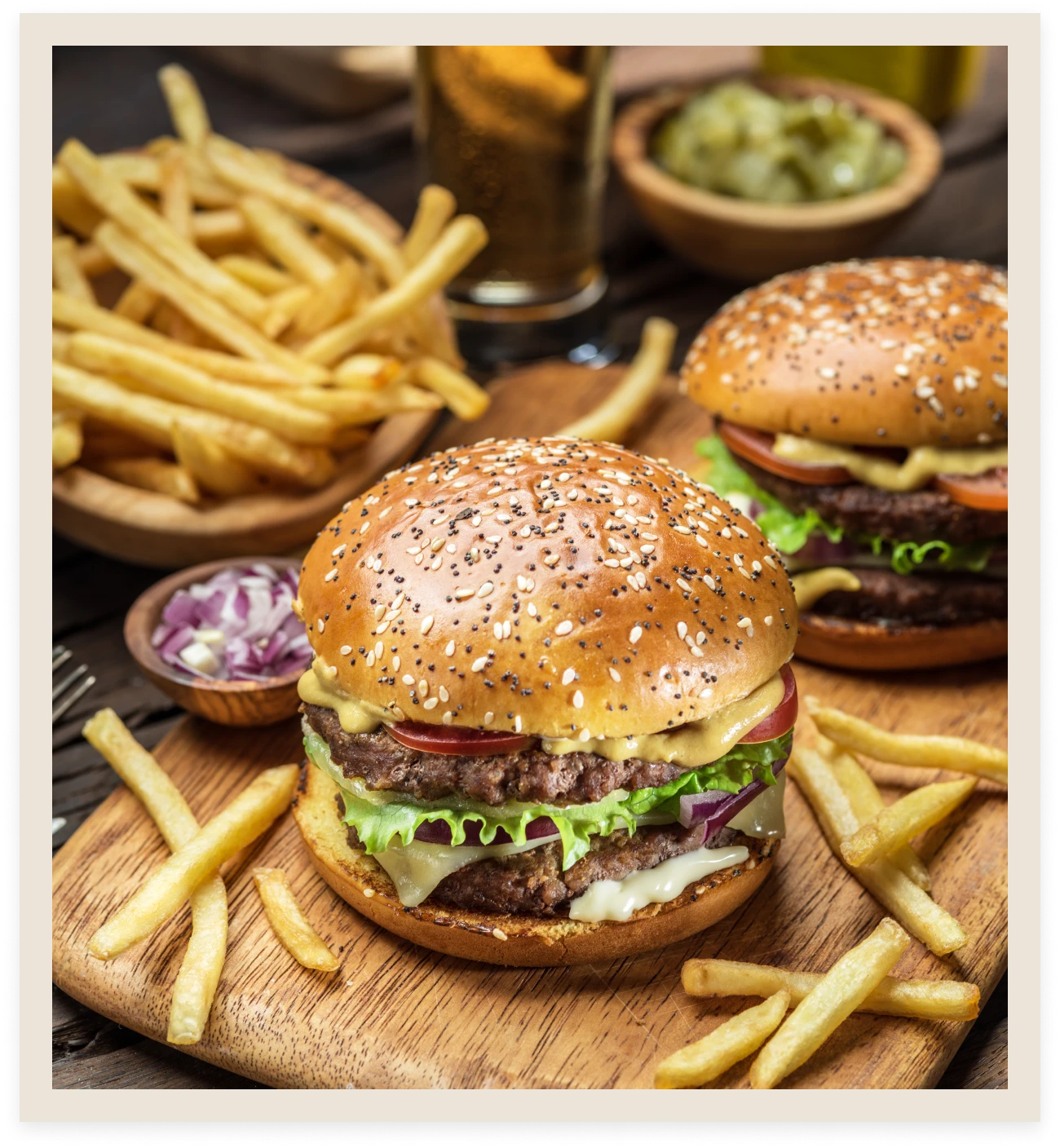 Burgers and fries on a wooden board.