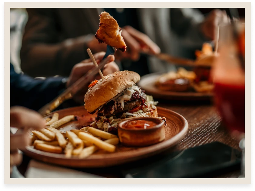 Burger and fries on a wooden plate.